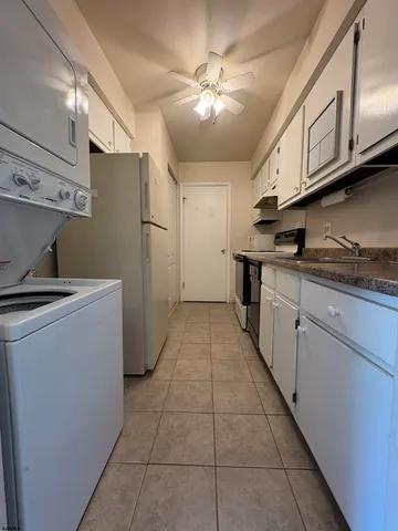 a kitchen with kitchen island granite countertop lots of white stainless steel appliances granite countertop a stove a sink and a refrigerator