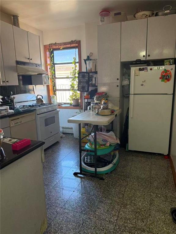 7404 3rd Avenue Brooklyn, NY 11209 - Photo 6 of 9 a kitchen with a refrigerator and a stove