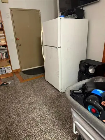 a white refrigerator freezer sitting next to a wooden wall