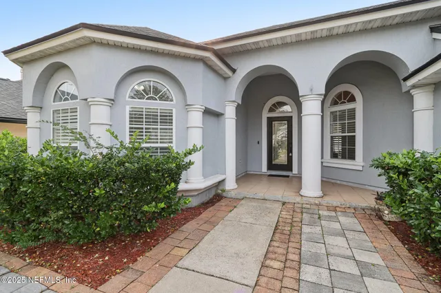a living room with furniture kitchen view and a wooden floor
