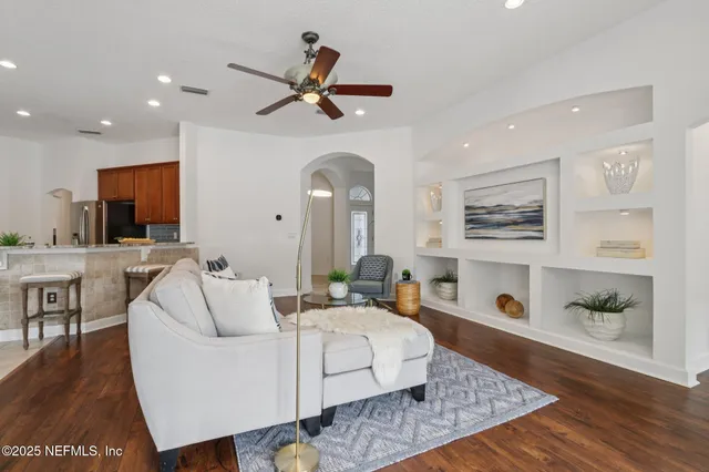 a living room with furniture a dining table and a potted plant