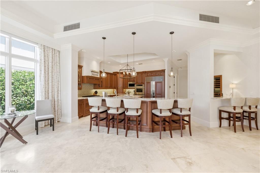 361 Pirates Bight Naples, FL 34103 - Photo 9 of 45 a very nice looking dining room with floor to ceiling windows and a chandelier