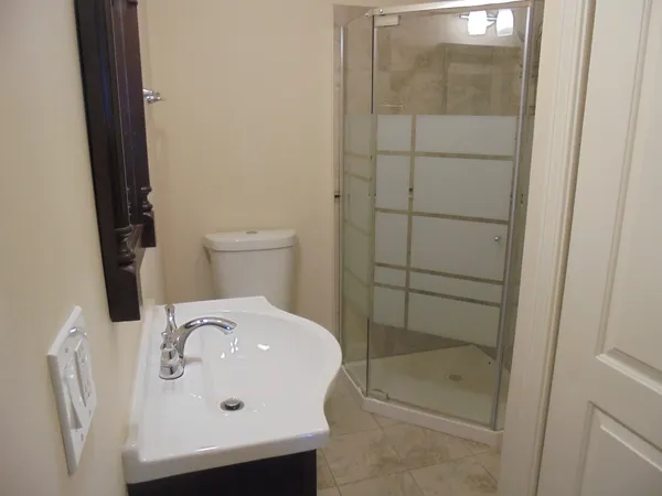 a bathroom with a sink a toilet and shower