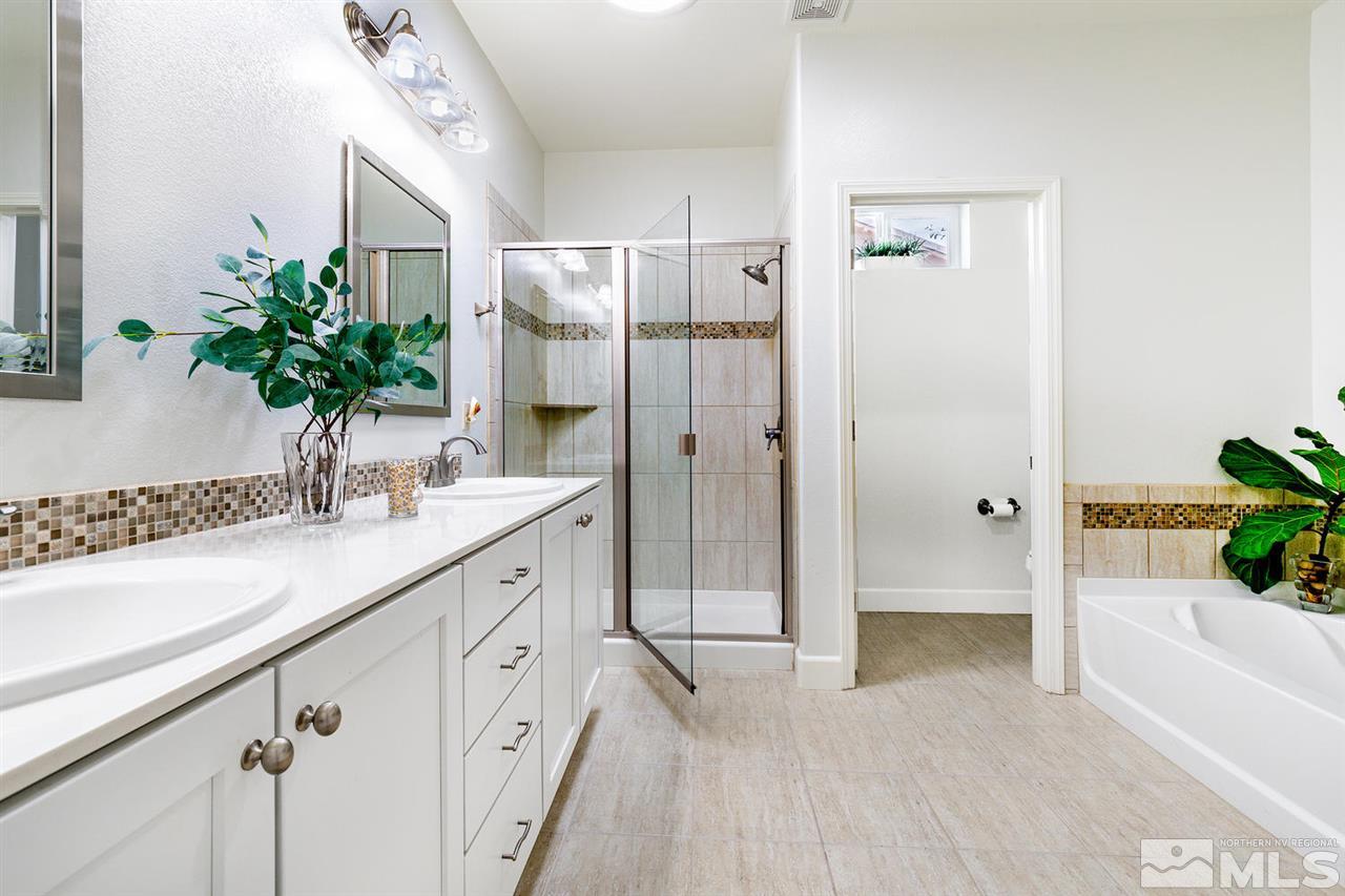 9645 Abigail Way Reno, NV 89521 - Photo 13 of 25 a bathroom with a double vanity sink a potted plant and a bathtub