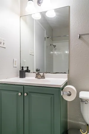 a bathroom with a sink mirror toilet and shower