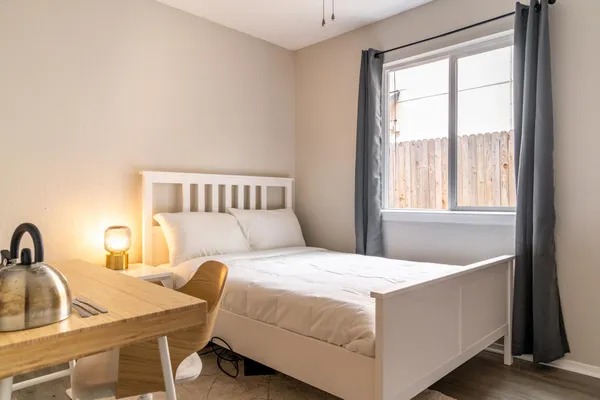 a bedroom with a bed and a large window