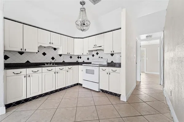 a kitchen with granite countertop white cabinets and white appliances