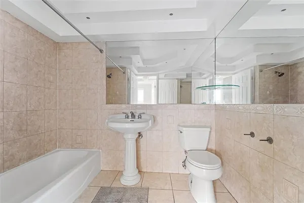 a bathroom with a sink a toilet a mirror and bathtub