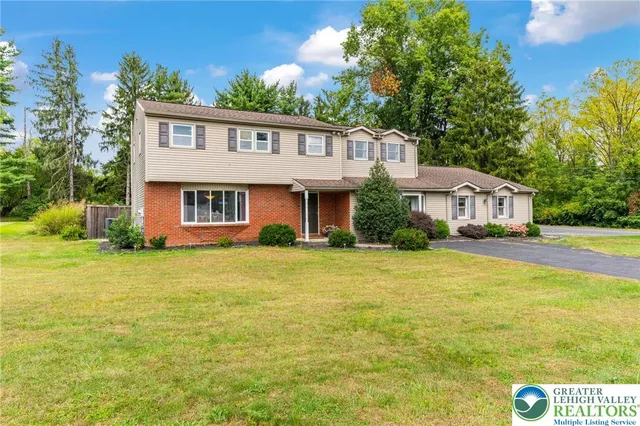 a front view of house with yard and trees