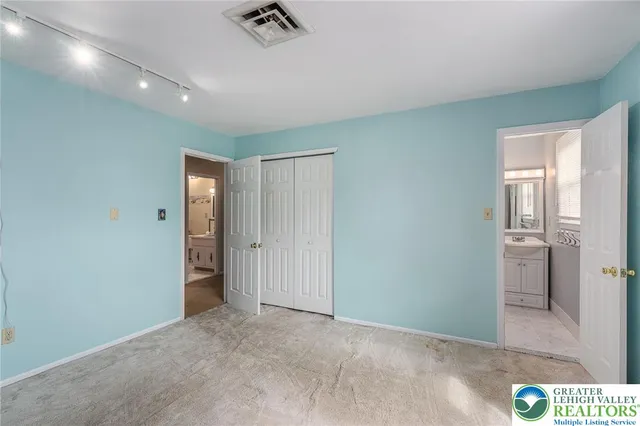 an empty room with closet and a bathroom