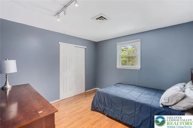 a bedroom with a bed and a lamp on the dresser