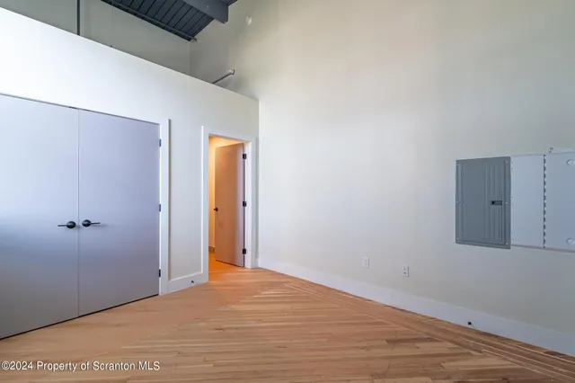 an empty room with wooden floor and windows