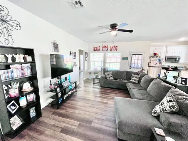 a living room with furniture a flat screen tv and a floor to ceiling window