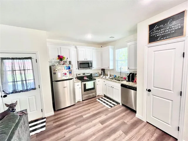 a kitchen with white cabinets and white appliances
