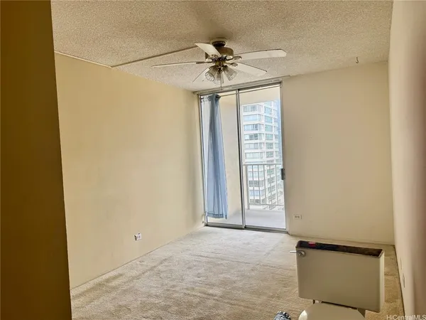 an empty room with a ceiling fan and a window