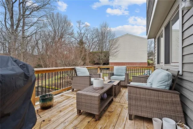 a roof deck with couches and wooden floor