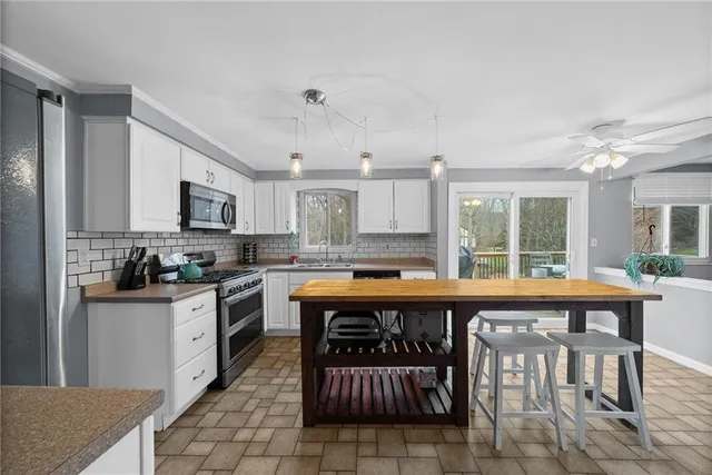 a large kitchen with kitchen island a sink table and chairs