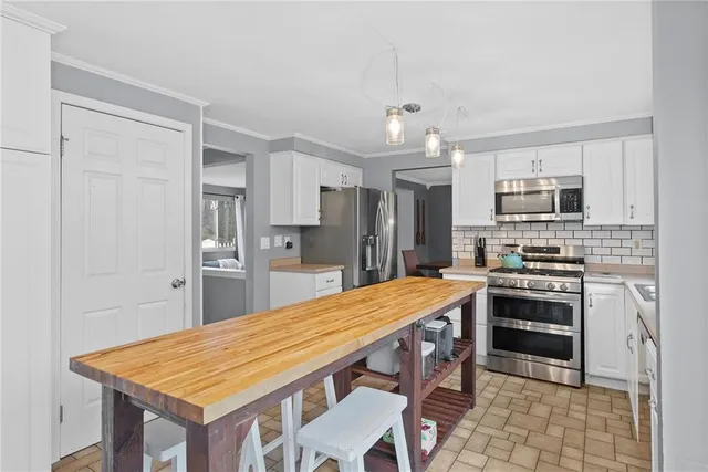 a kitchen with stainless steel appliances a stove a sink refrigerator and microwave