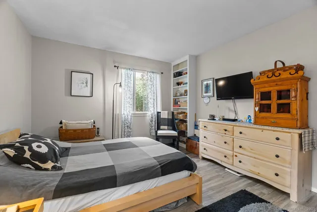 a bedroom with a bed and a flat tv screen on the dresser