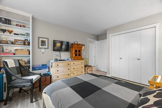 a bedroom with a bed and a chair in it