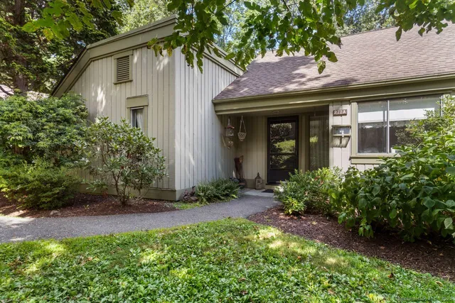 a view of a white house with a large windows and plants