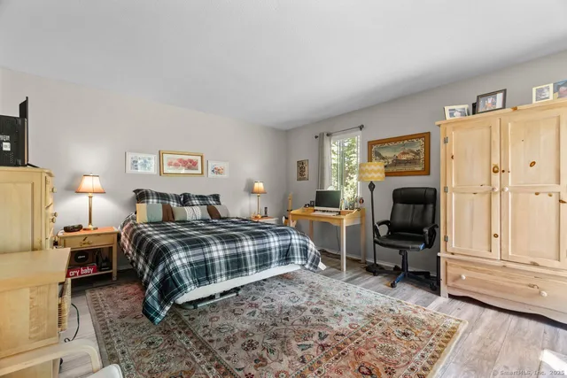 a bedroom with a bed and wooden floor