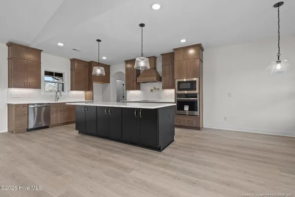 a kitchen with kitchen island a sink stainless steel appliances and cabinets