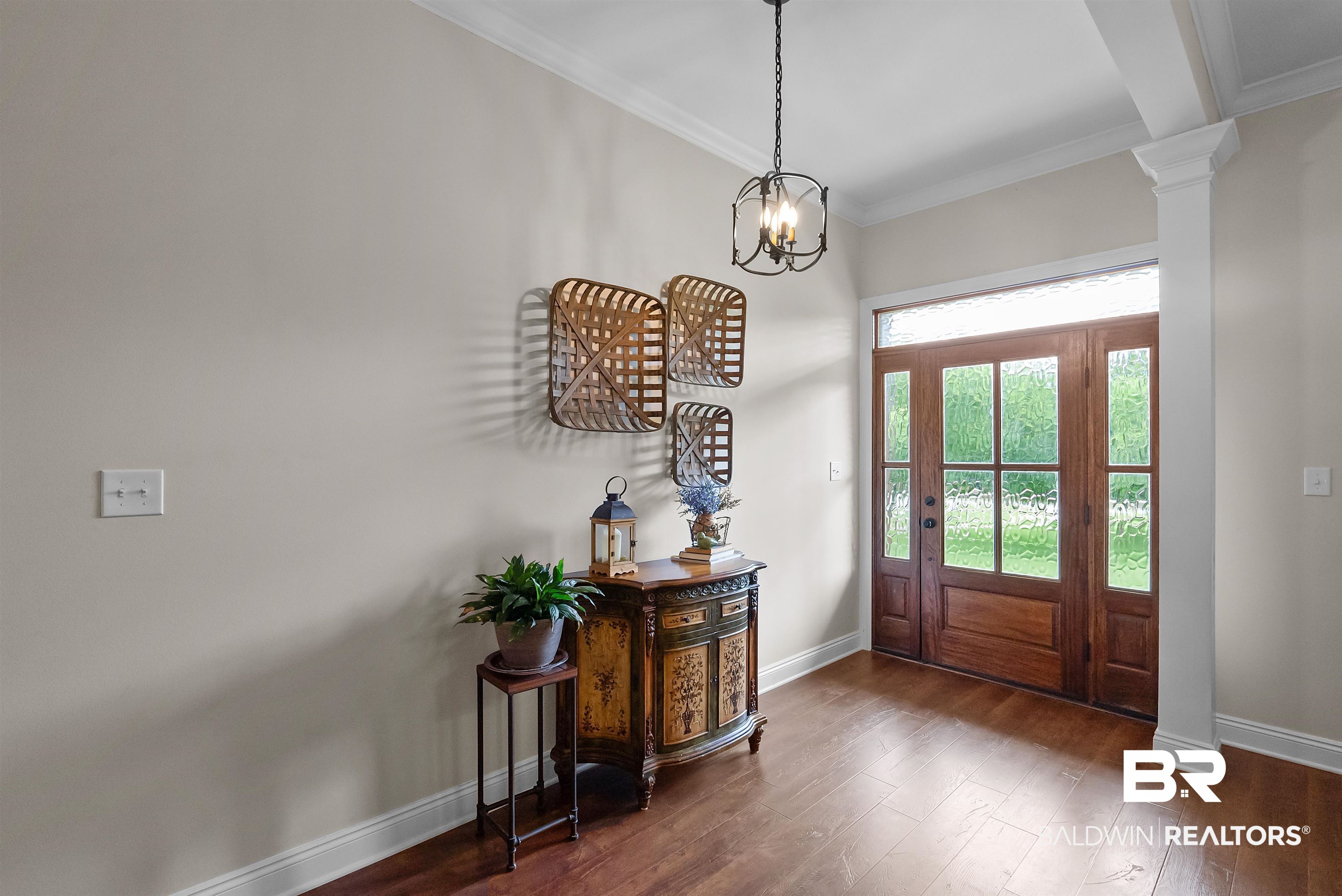 12070 Comalander Road Fairhope, AL 36532 - Photo 3 of 50 Entryway featuring a wood-panel door with glass inserts and transom, wood-finish flooring, crown molding, and a decorative ceiling fixture