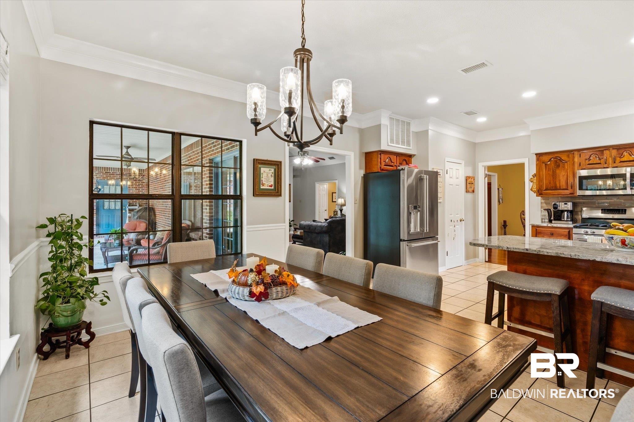 7360 Bridgewood Court Mobile, AL 36695 - Photo 10 of 30 Tiled dining room featuring ceiling fan with notable chandelier and crown molding