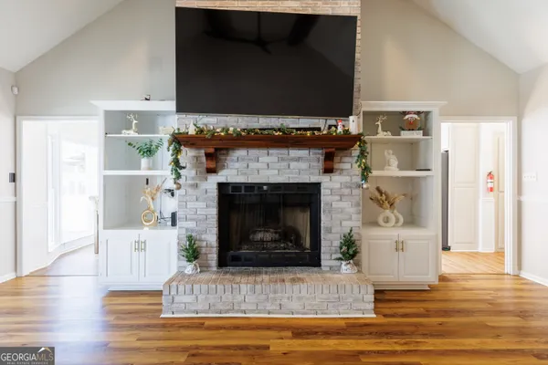a living room with stainless steel appliances kitchen island granite countertop furniture and a chandelier