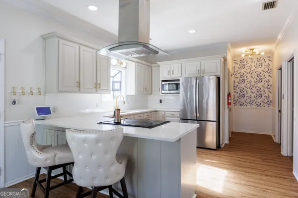 a kitchen with stainless steel appliances granite countertop a stove and a white cabinets