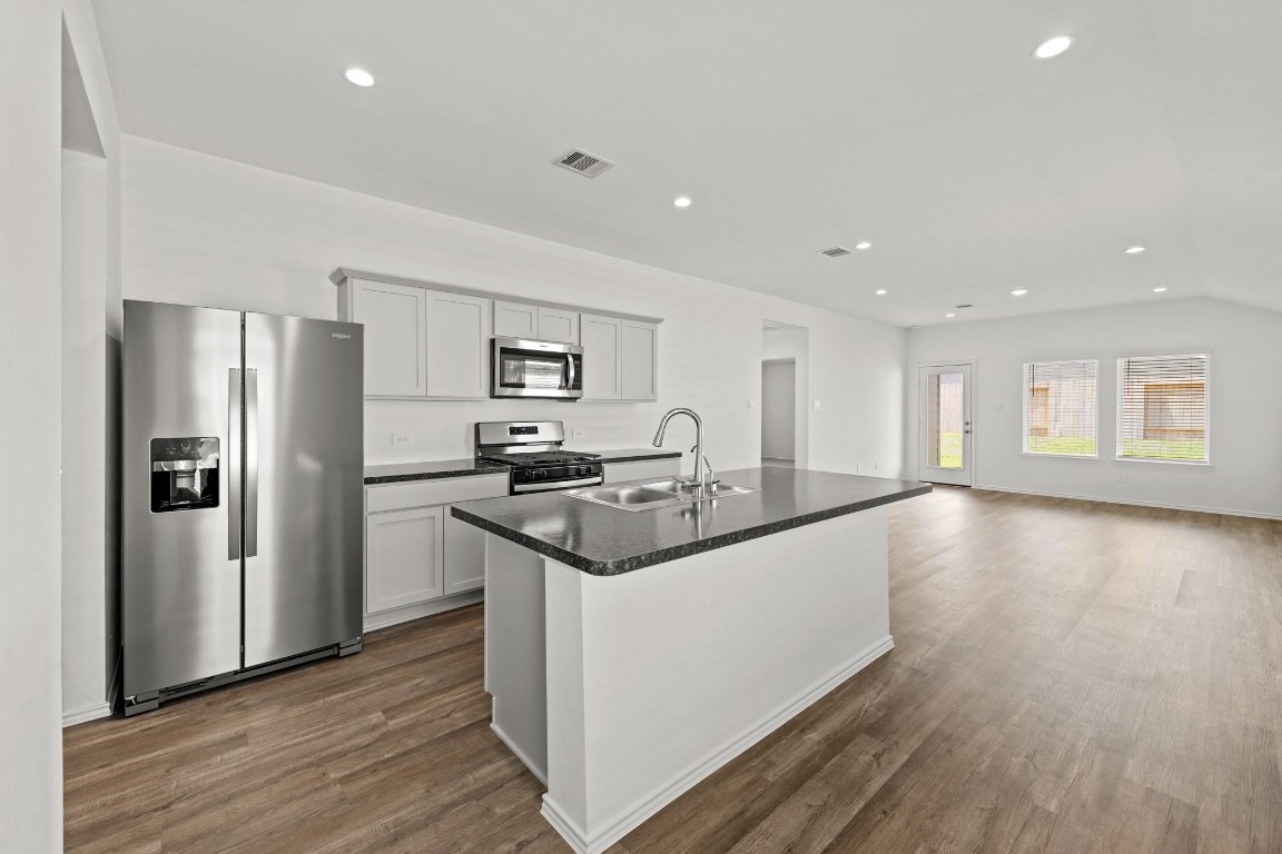 5710 Sycamore Glen Dr Spring Spring, TX 77373 - Photo 6 of 18 a kitchen with stainless steel appliances granite countertop a refrigerator a stove and a wooden floors