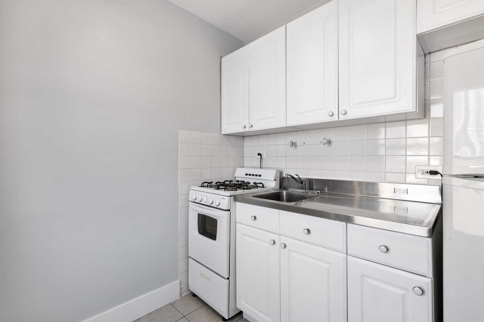 5858 North Sheridan Road, Unit 805 Chicago, IL 60660 - Photo 5 of 14 a kitchen with granite countertop white cabinets and white appliances