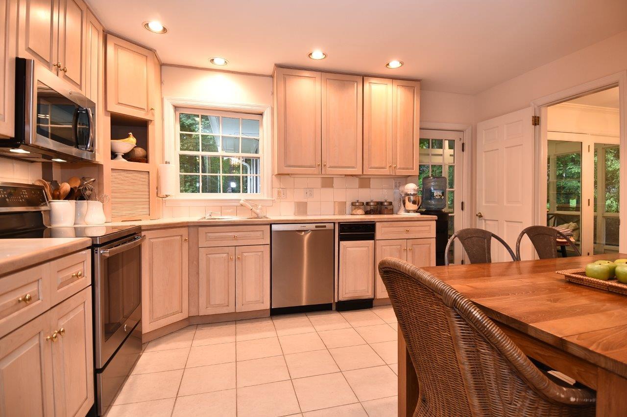 287 Briscoe Road New Canaan, CT 06840 - Photo 12 of 22 a kitchen with kitchen island granite countertop a stove a sink a dining table and chairs