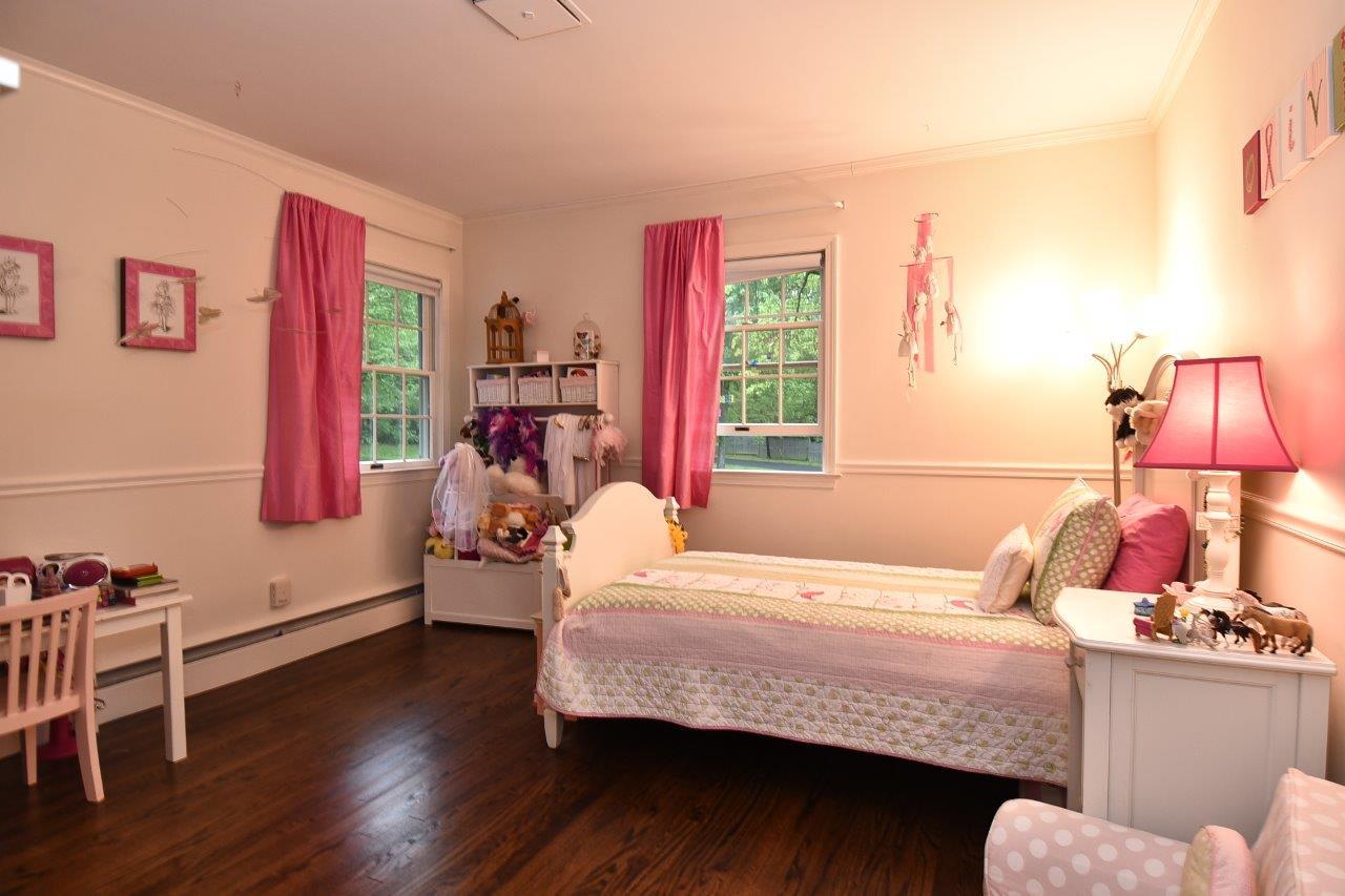 287 Briscoe Road New Canaan, CT 06840 - Photo 18 of 22 a bedroom with a bed and wooden floor