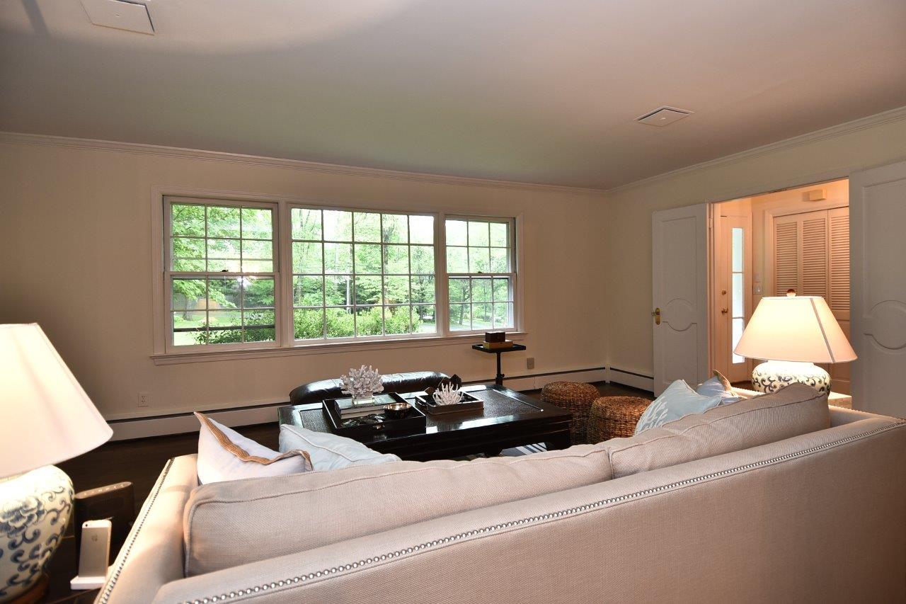 287 Briscoe Road New Canaan, CT 06840 - Photo 6 of 22 a living room with a bed furniture and a large window