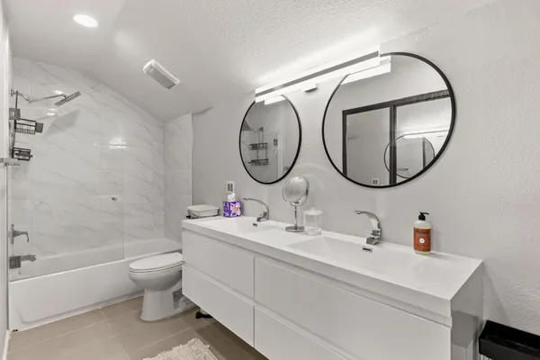 a bathroom with a toilet a sink a bathtub and a mirror