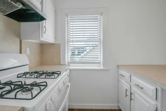 a kitchen with a stove a sink and a window