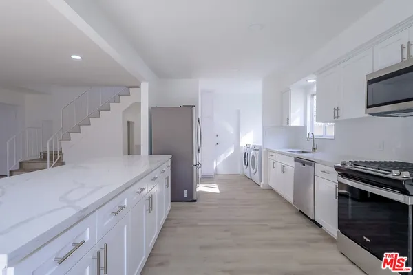 a large kitchen with a stove and a sink
