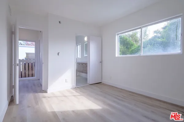 an empty room with large windows and a livingroom