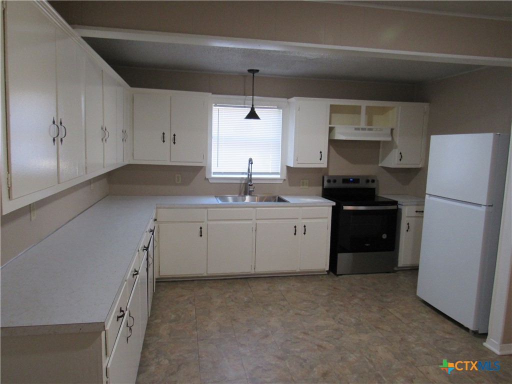 1002 Duncan Avenue Killeen, TX 76541 - Photo 4 of 14 a kitchen with a sink a stove a refrigerator and cabinets