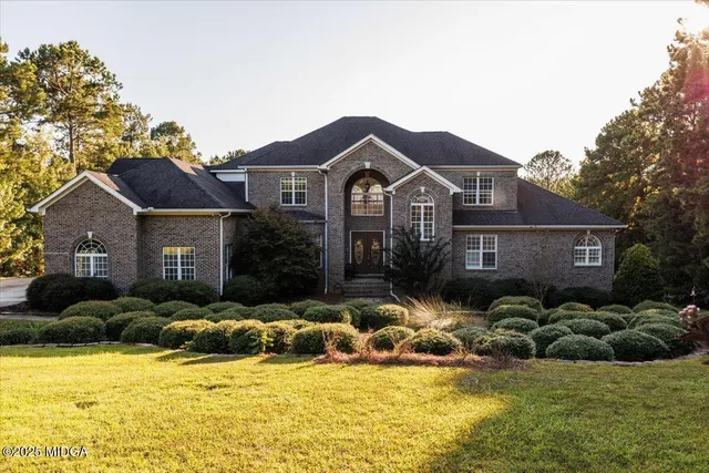 a view of a house with a big yard and large trees