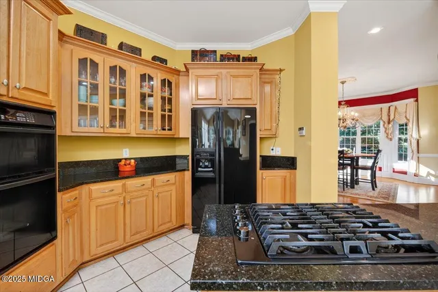 a kitchen with stainless steel appliances granite countertop a refrigerator and a stove