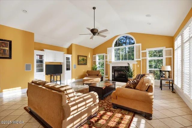 a living room with fireplace furniture and a large window