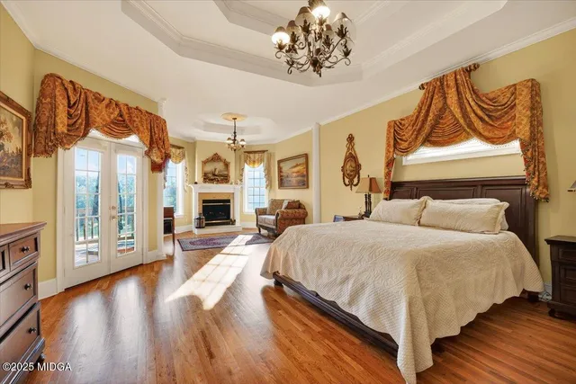 a spacious bedroom with a bed and wooden floor