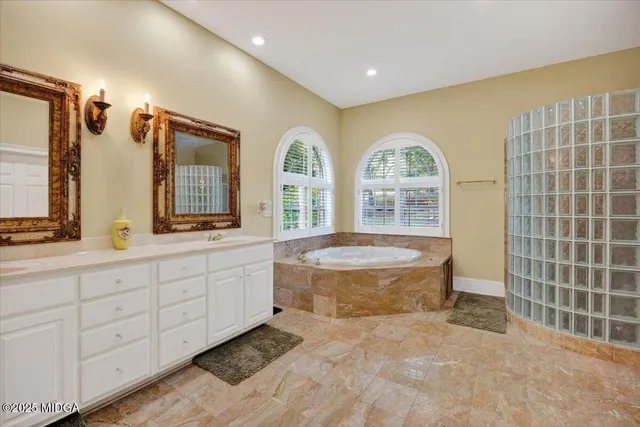a spacious bathroom with a double vanity sink a mirror and a bathtub