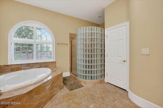a spacious bathroom with a bathtub and a shower