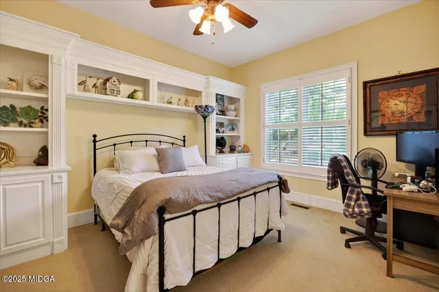 a bedroom with a bed window and a flat screen tv