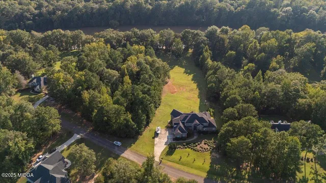 an aerial view of a house with swimming pool and red chairs