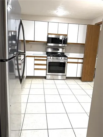 a kitchen with a stove a refrigerator and cabinets